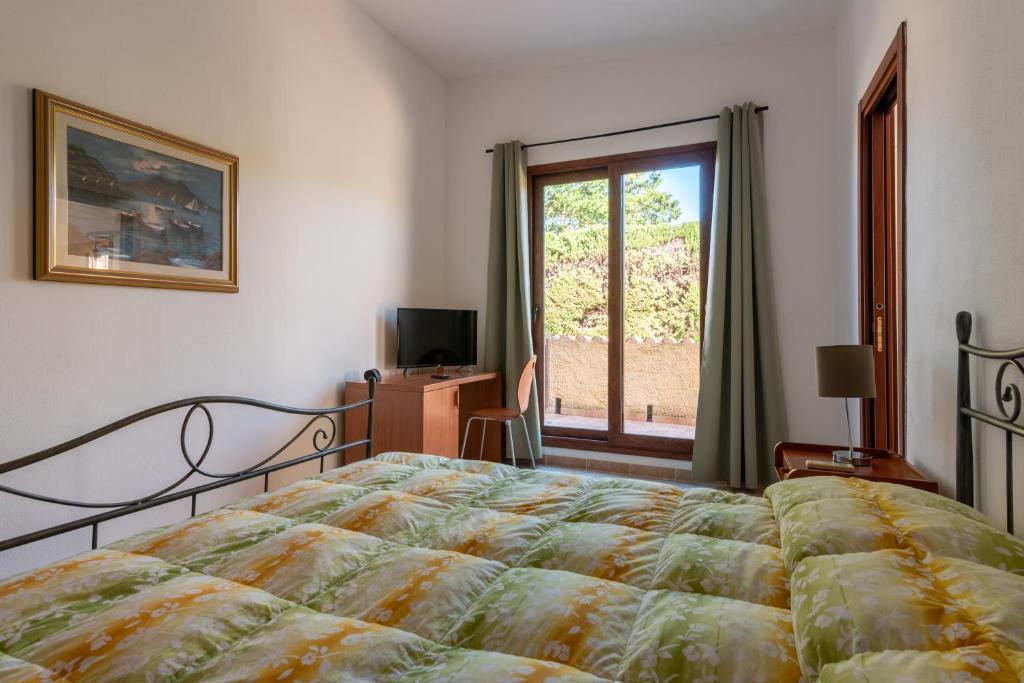 een slaapkamer met een bed en een raam bij Bonsai B&B Alghero in Santa Maria la Palma