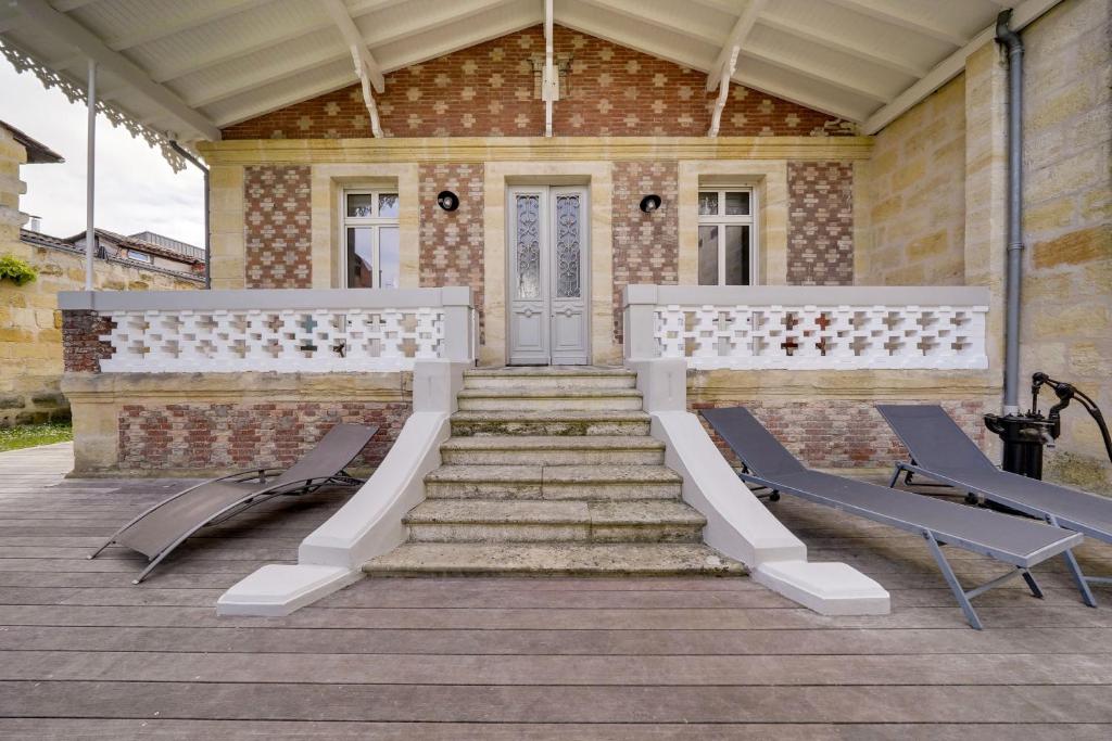 eine Veranda mit 2 Stühlen und Treppen sowie ein Gebäude in der Unterkunft L'Arcachonnaise by Cocoonr in Bordeaux