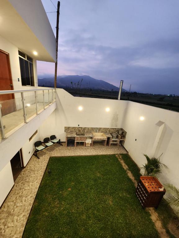 a balcony with a couch and a grass yard at Hermosa y acogedora casa en Huaral in Lima