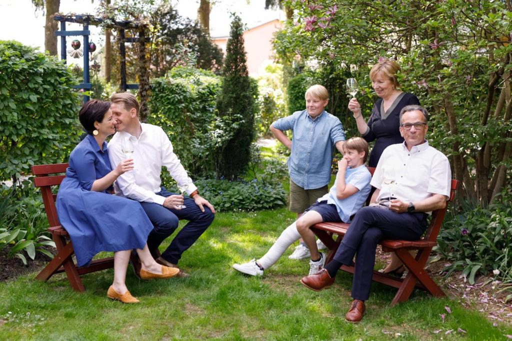 un grupo de personas sentadas sobre sillas en un jardín en Weinlandhof, en Gamlitz