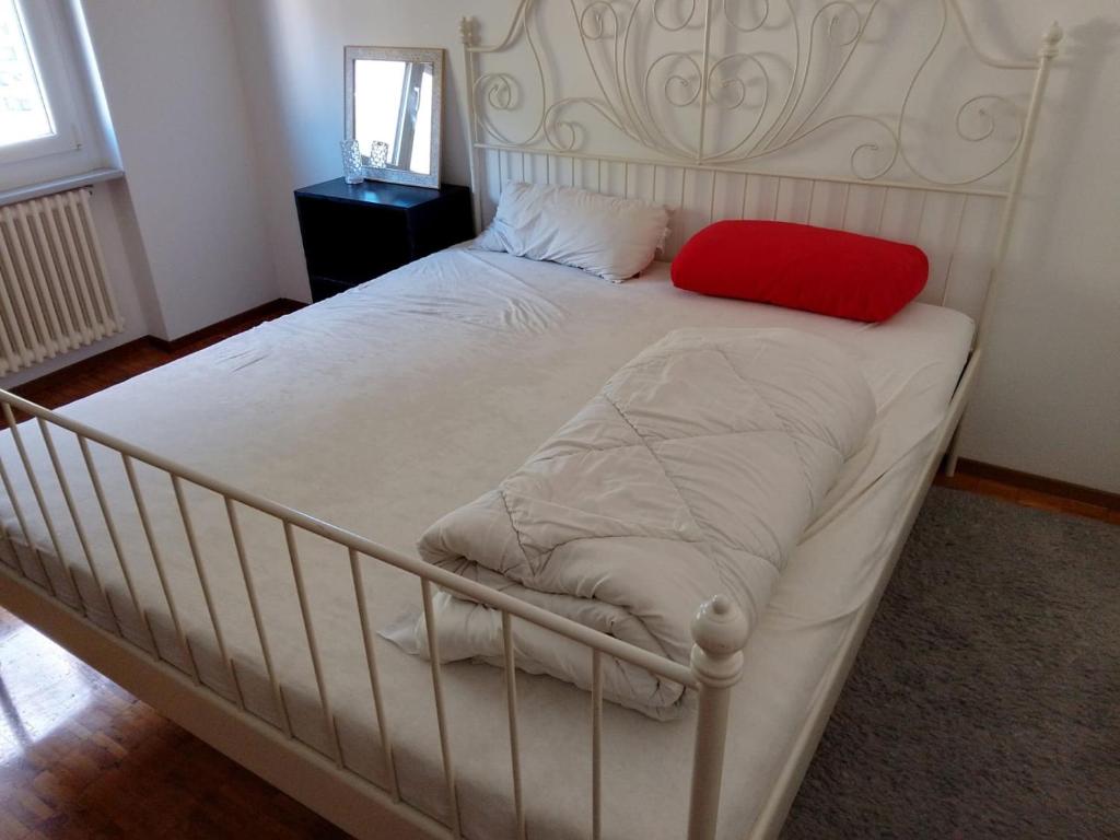 un letto bianco con un cuscino rosso sopra di Castle-View Bellinzona a Bellinzona