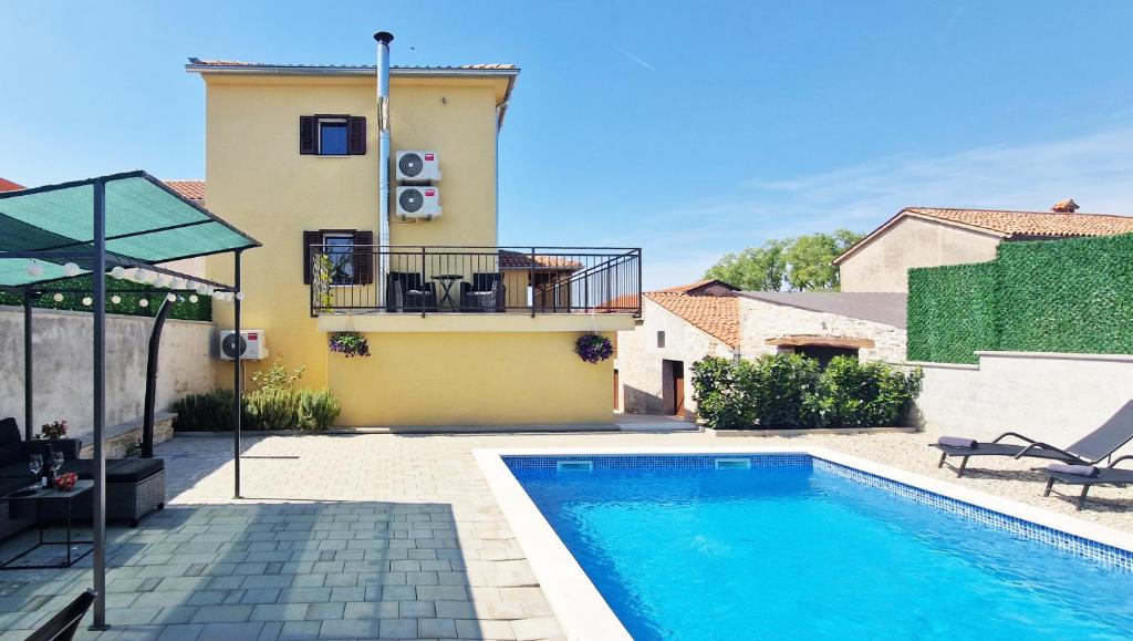 - une piscine en face d'une maison dans l'établissement Beautiful Villa Casa Romito with pool in Kastelir, à Kaštelir