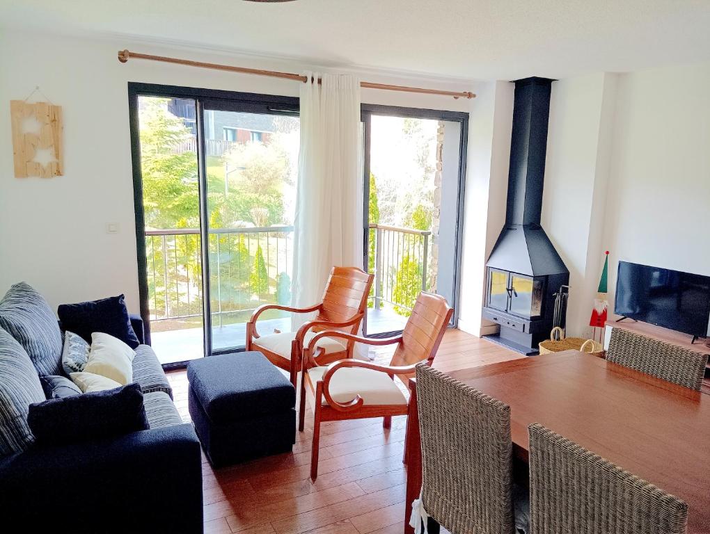 Una sala de estar con una mesa y una chimenea. en Les Ferreries, en Saillagouse