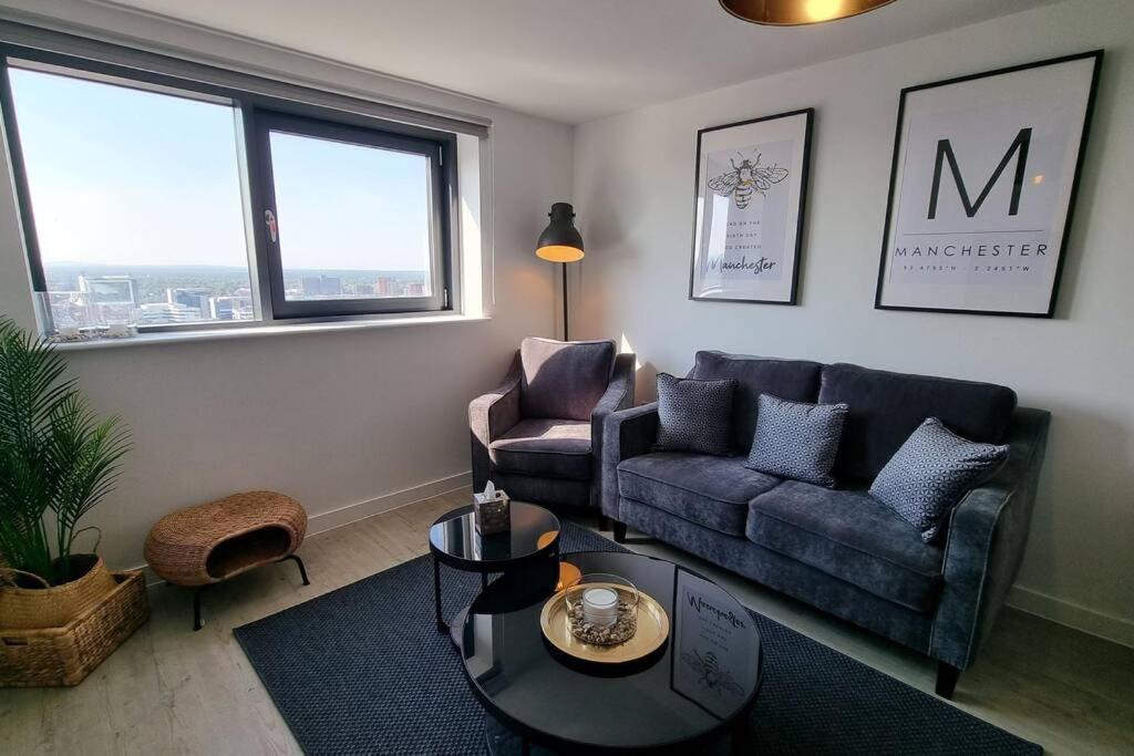 uma sala de estar com um sofá e uma mesa em 2 Bedroom Penthouse em Manchester