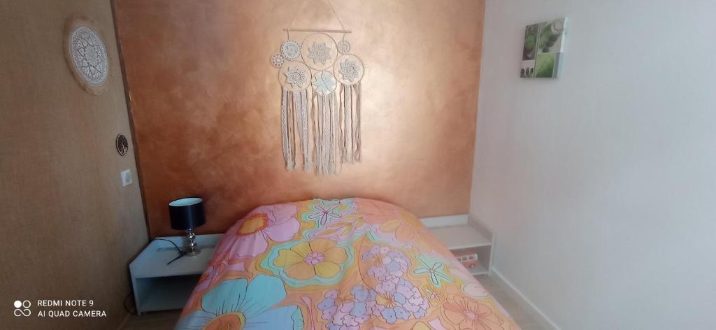 um quarto com uma cama com uma colcha floral em Charmant appartement vue mer em Narbonne Plage