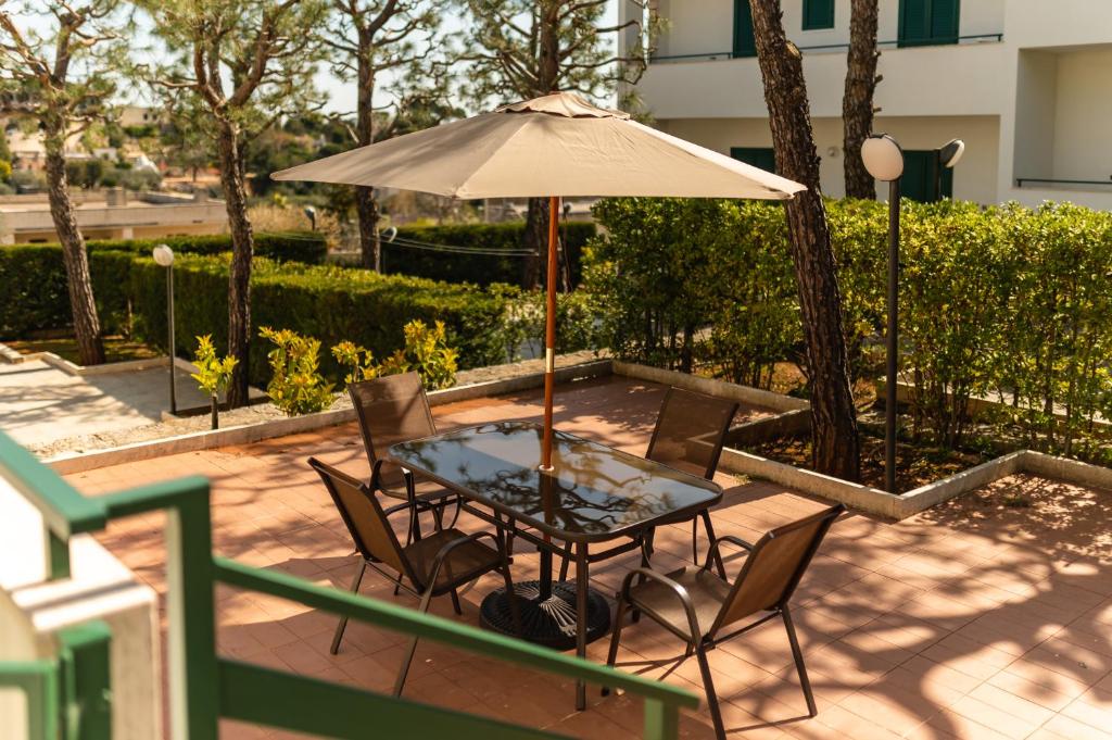 een tafel en stoelen met een parasol op een patio bij Giu al Minareto North in Selva di Fasano