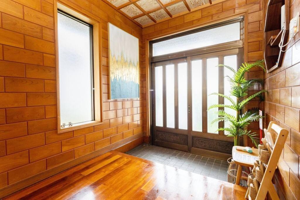 a room with a large window and a wooden door at 瑞海雲 in Nago