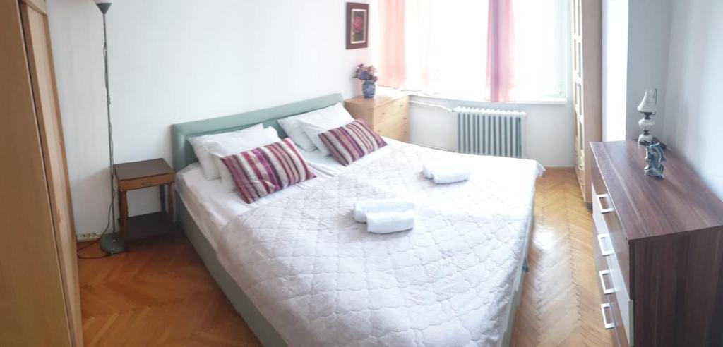 um quarto com uma grande cama branca com almofadas em 2 Bedroom Apartment, Grbavicka em Sarajevo