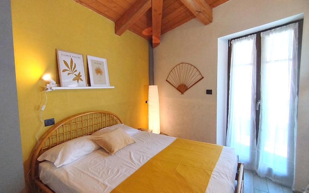 - une chambre avec un lit et une grande fenêtre dans l'établissement [Centro Storico] Casa con Wi-Fi e Parcheggio a 100m, à Saluces