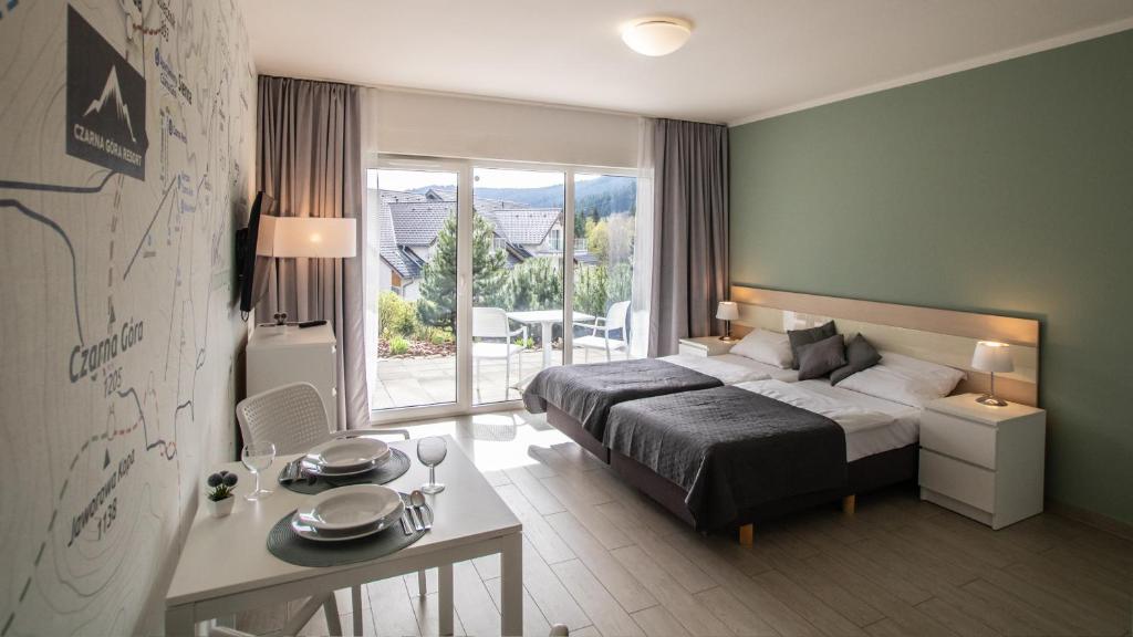 una camera d'albergo con letto, tavolo e scrivania di Livigno - Czarna Góra Resort by Sun & Snow z nielimitowanym basenem a Sienna