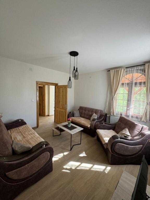 Sala de estar con 2 sofás y mesa en Vikendica Ozren en Soko Banja