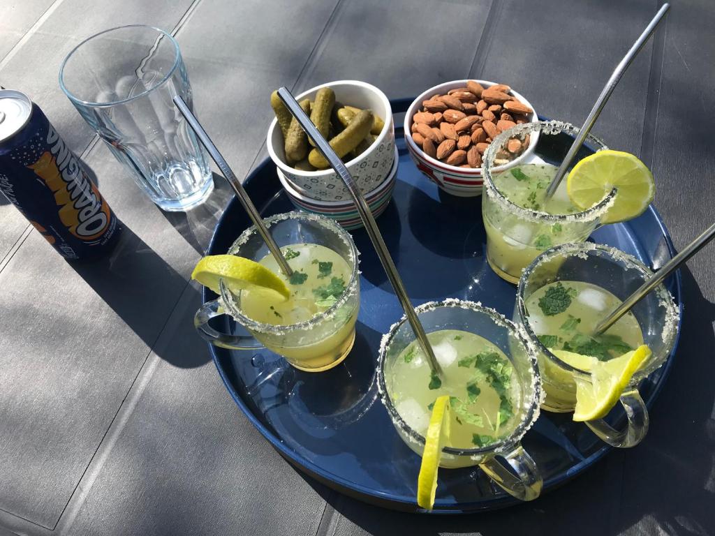 un plateau avec quatre boissons sur une table avec des collations dans l'établissement Roz Avel, à Caurel