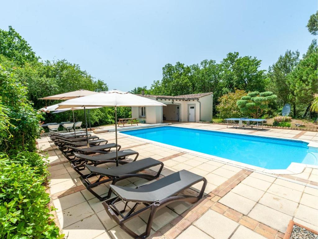 a swimming pool with chairs and umbrellas next to a pool at Manoir de Montréal - West Wing in Montréal