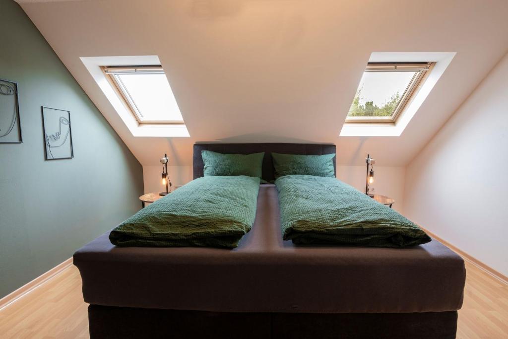een bed in een kamer met 2 ramen bij Ferienwohnung "Tee Tied" 35225 in Hesel