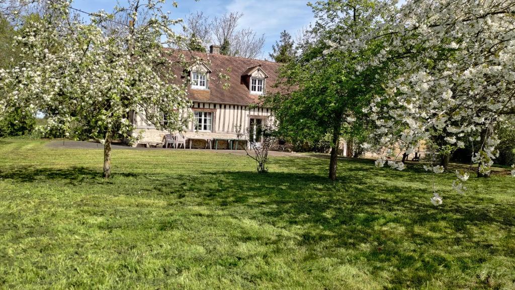 une grande maison avec des arbres devant elle dans l'établissement Au coeur des marais, à Varaville