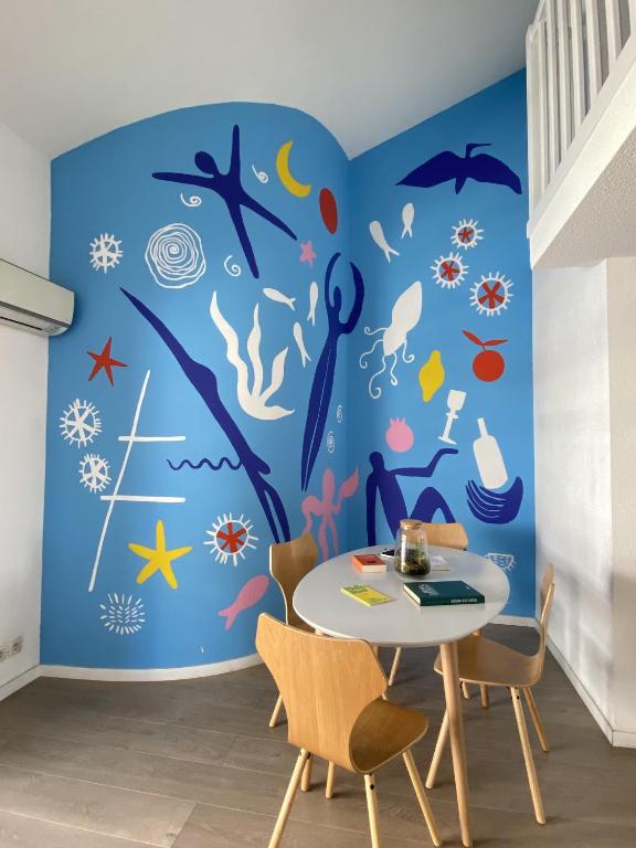 une salle à manger avec un mur bleu sur le thème de l'océan dans l'établissement TOBIAS - Appartement Duplex 4 personnes Quartier Riquier Nice, à Nice