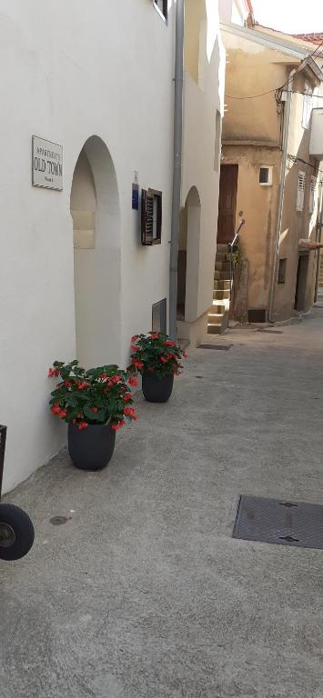 three potted plants sitting on the side of a building at Old Town Lux in Baška