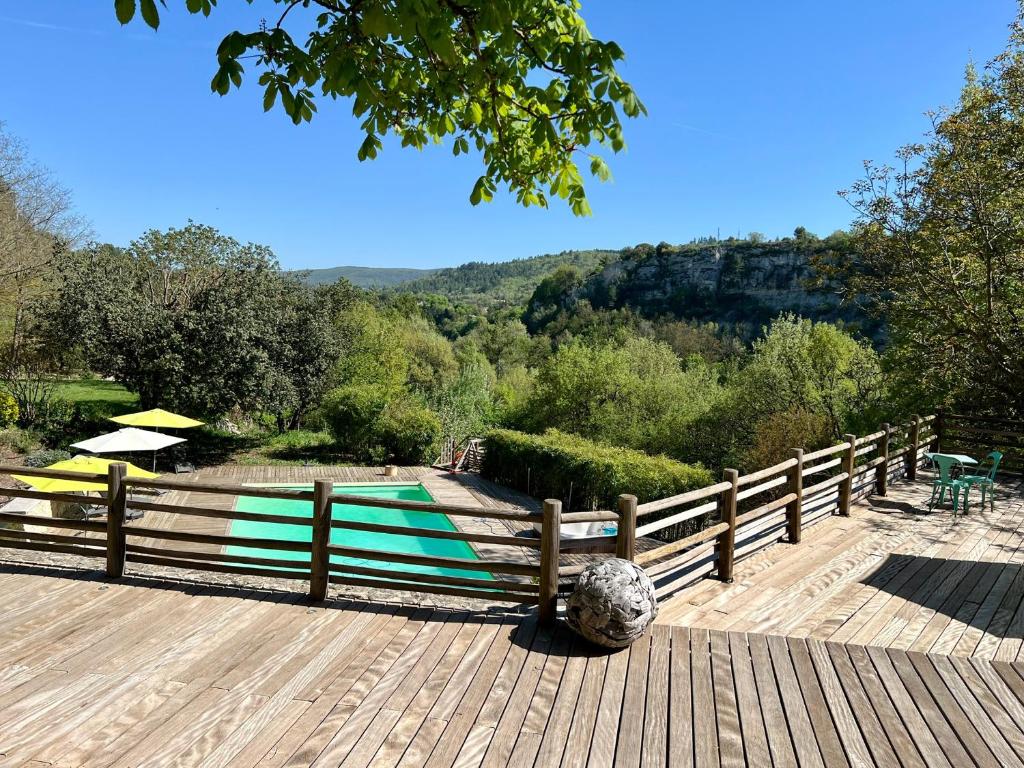 une terrasse en bois avec une clôture et une piscine dans l'établissement Gîte Nature en Luberon, à Céreste