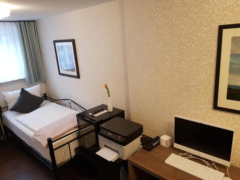 a bedroom with a bed and a desk with a computer at Monopol Boutique Hotel in Bremen