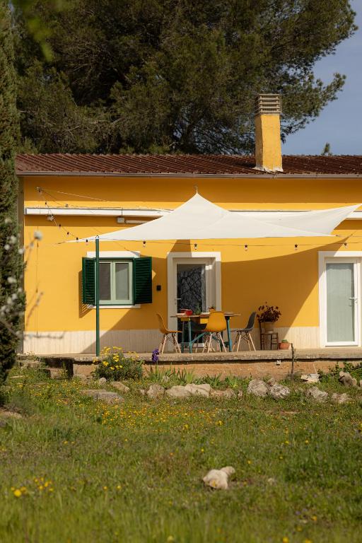 a yellow house with a table and chairs at Casina al Castello - Natura e Relax in Castel del Monte