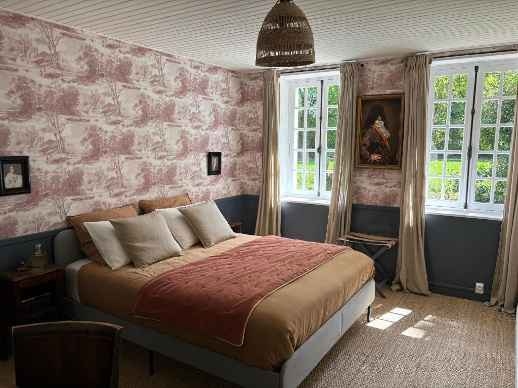 a bedroom with a bed with a pink wall at La haute trémière in Charenton sur Cher