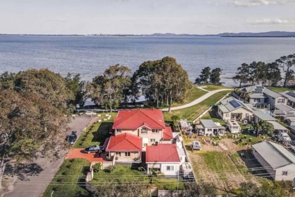 an aerial view of a house with red roofs at Aircabin - Tuggerawong - Lake Front - 9 Beds House in Karraganbah