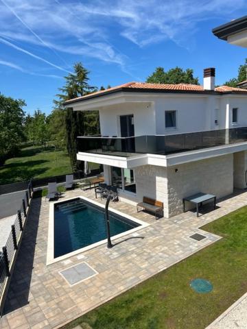 a house with a swimming pool in front of it at Villa Tadini JOY in Babići