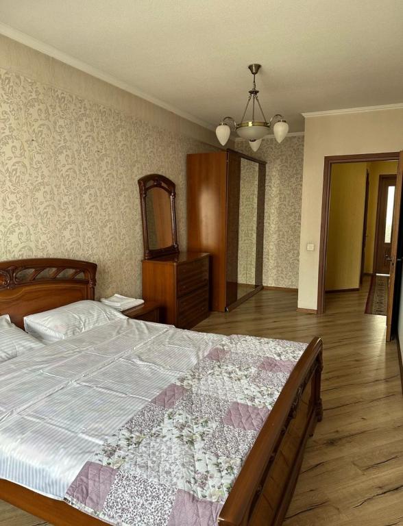 a bedroom with a large bed and a mirror at guest house djal in Bishkek
