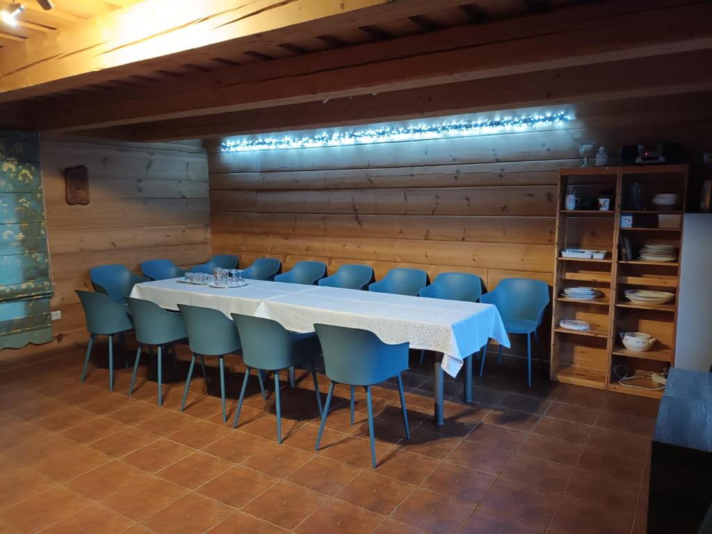 un comedor con una mesa blanca y sillas azules en Prystovų sodyba en Prystovai