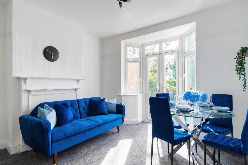 salon z niebieską kanapą i szklanym stołem w obiekcie Livestay 3 Bed House in Hendon Private Garden&Parking w mieście Colindale