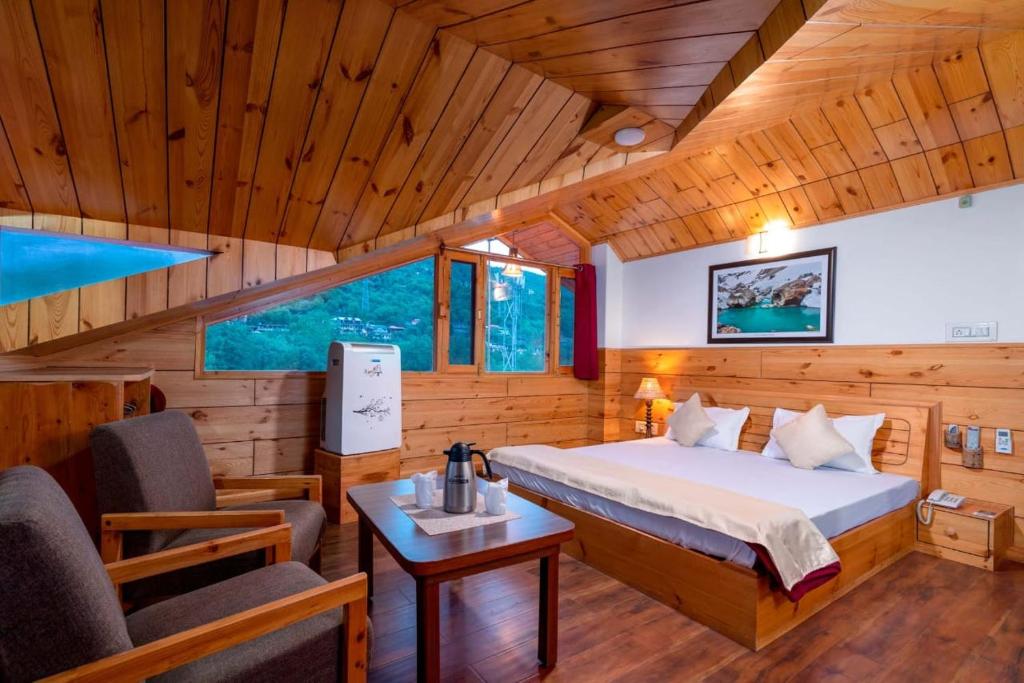 - une chambre avec un lit, une table et des chaises dans l'établissement Hotel Kullu Valley, à Kulu