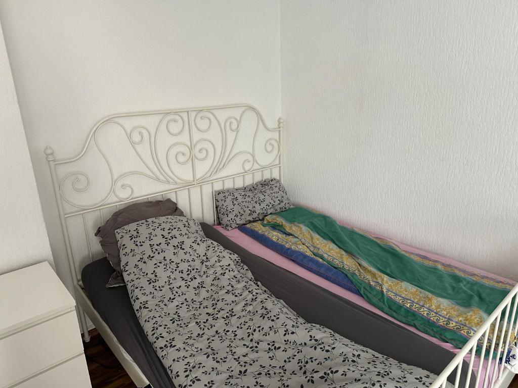 ein kleines Schlafzimmer mit einem Bett mit einem weißen Kopfteil in der Unterkunft Apartment in Hannover