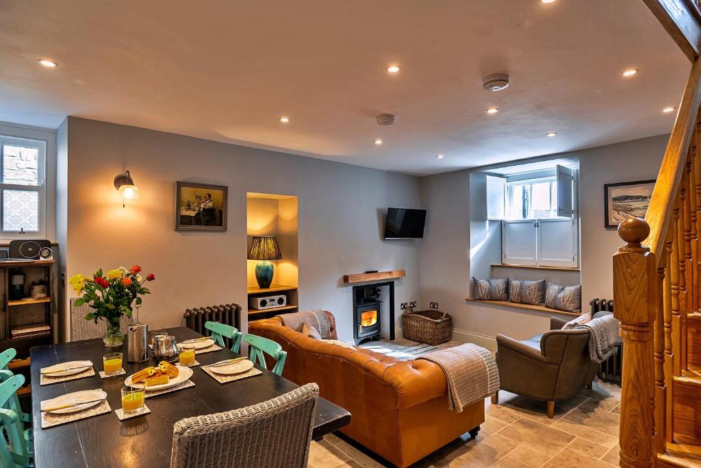 a living room with a table and a couch at Finest Retreats - Potters Cottage in Fowey