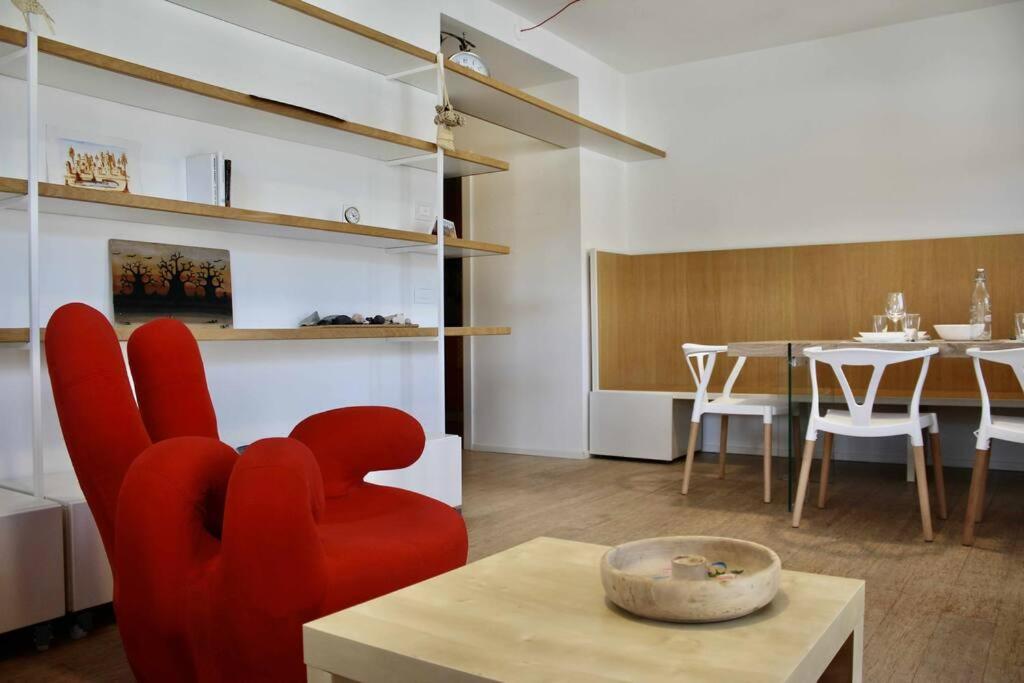uma sala de estar com uma cadeira vermelha e uma mesa em Casa del Tempo Elsa Tassullo Ospitar em Tassullo