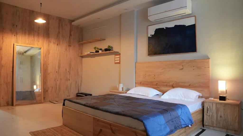 ein Schlafzimmer mit einem großen Bett und einer Holzwand in der Unterkunft Art Cave Studio in Jaipur