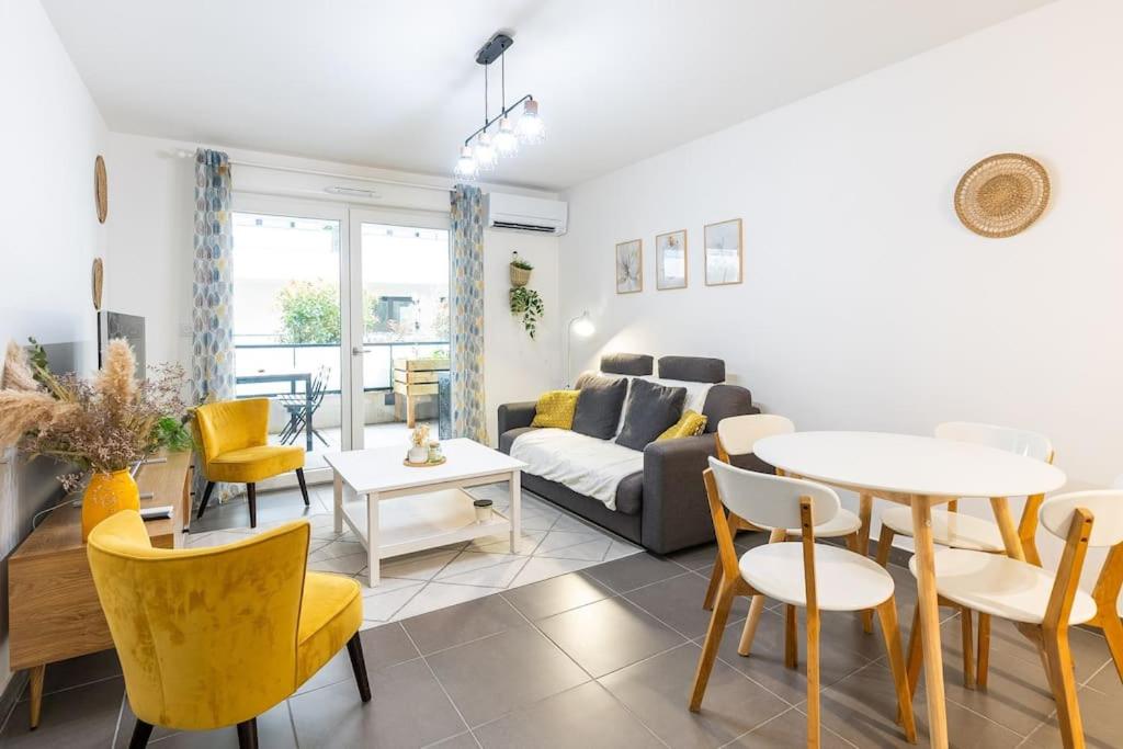 un salon avec un canapé, une table et des chaises dans l'établissement Le Barcelone, Beau T2, Clim, Terrasse,Centre ville, à Montpellier