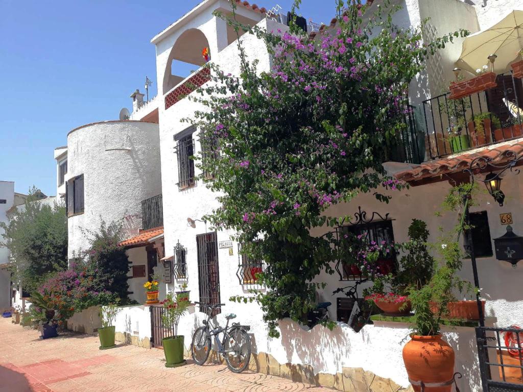 un edificio blanco con bicicletas estacionadas frente a él en Casa Pelagia, maison de pêcheur avec amarre, en Empuriabrava