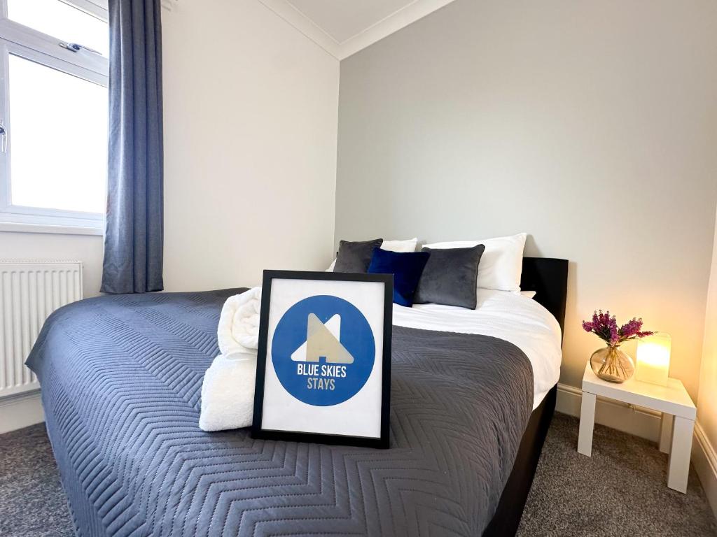 a bedroom with a bed with a sign on it at Wrightson House by Blue Skies Stays in Stockton-on-Tees