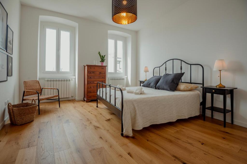 um quarto com uma cama e piso em madeira em Elegant Apartment 28 San Giacomo em Trieste