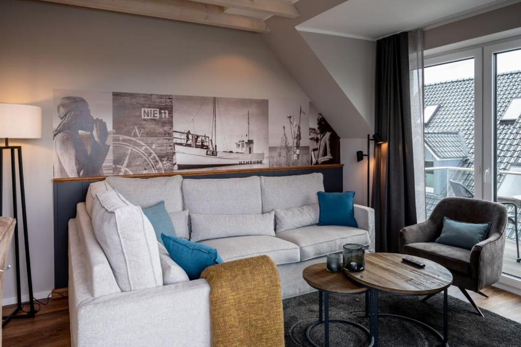 een woonkamer met een witte bank en een tafel bij 4Hafenzeiten - Ferienwohnung NIE 11 Hamburg in Timmendorfer Strand