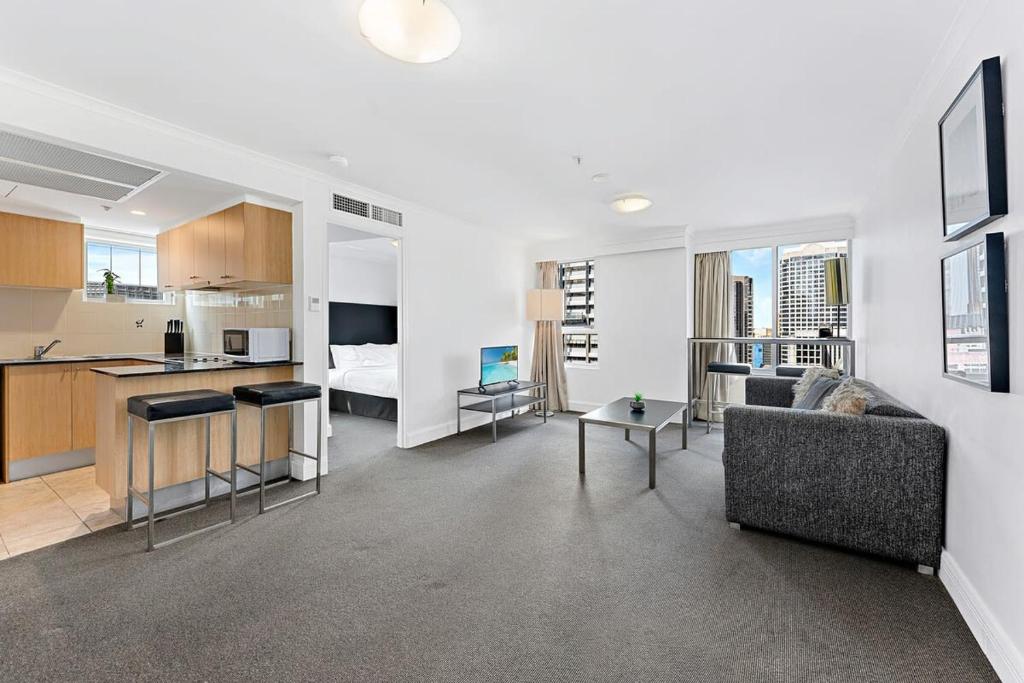 a living room with a couch and a kitchen at AirCabin - Sydney CBD - Best Location -1 Bed Apt in Sydney