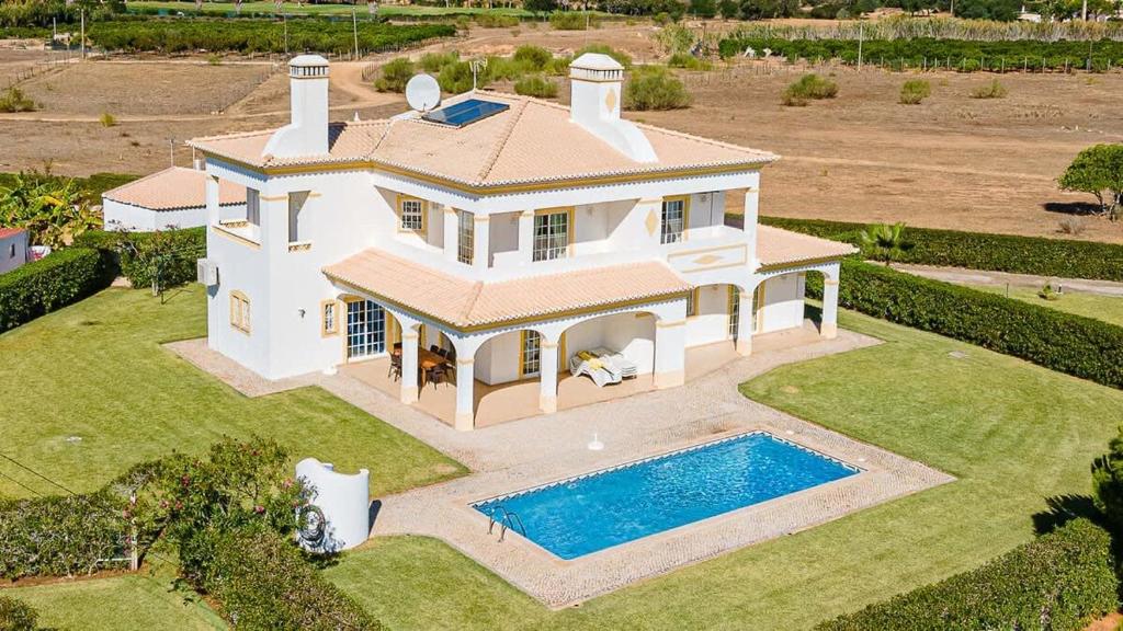 una vista aérea de una casa con piscina en Villa Mina - Large house sleeps 9, walk to beach, golf and shops en Guia