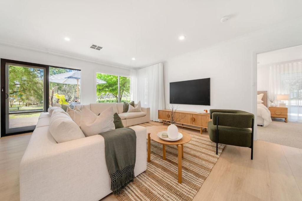 a living room with a white couch and a tv at The Grape Escape Location and style on Shiraz Trail in McLaren Vale