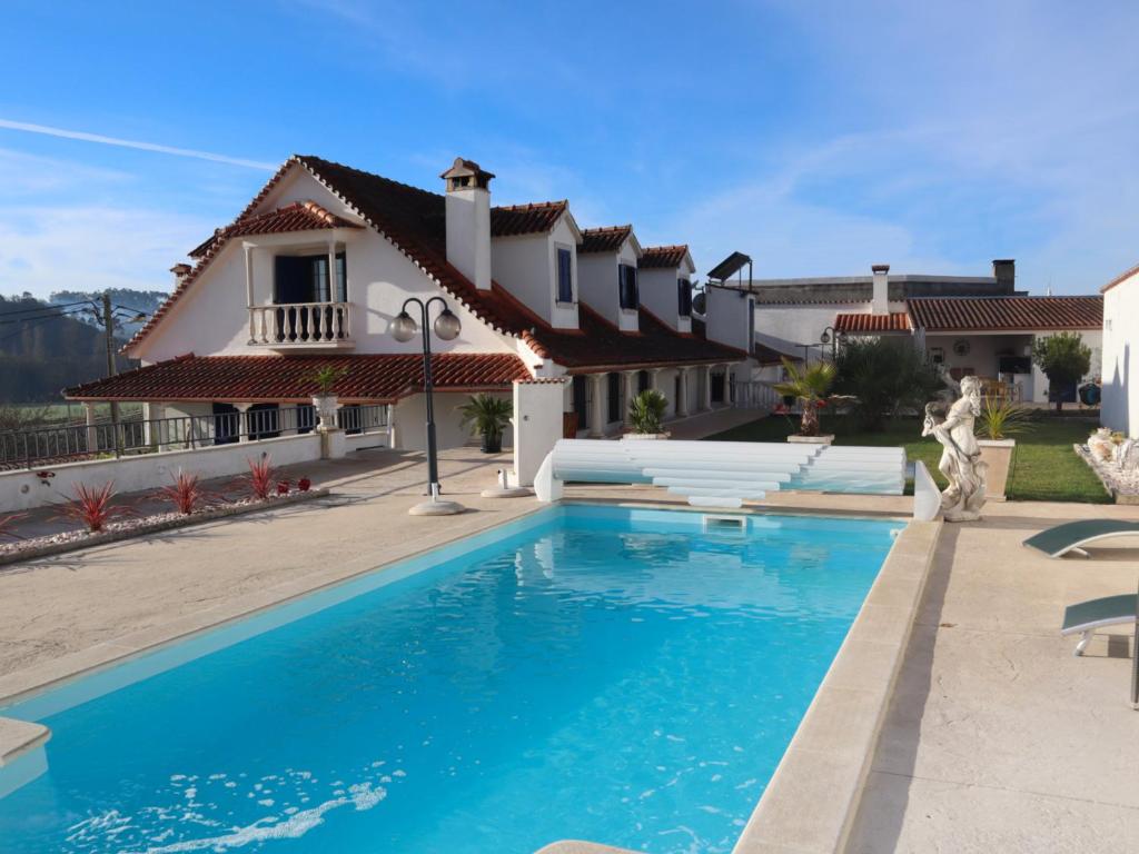 uma villa com piscina em frente a uma casa em Casal dos Frades em Fontainhas