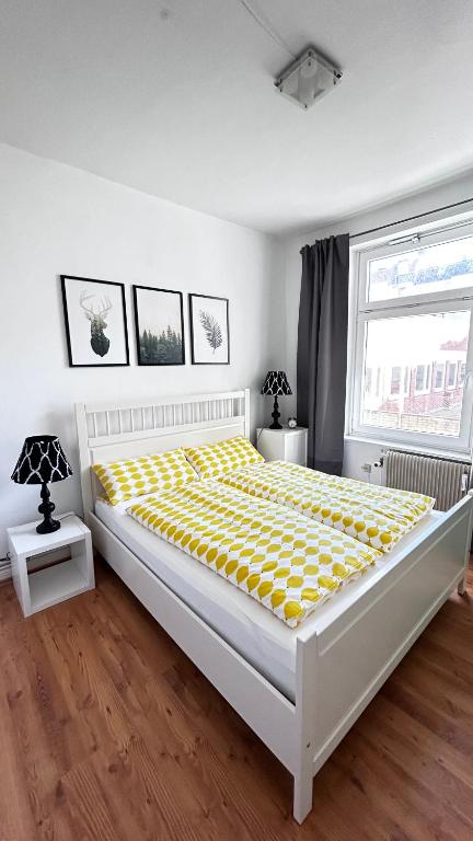 une chambre avec un grand lit avec une couverture jaune dans l'établissement Nord Ost Apartment, à Kiel