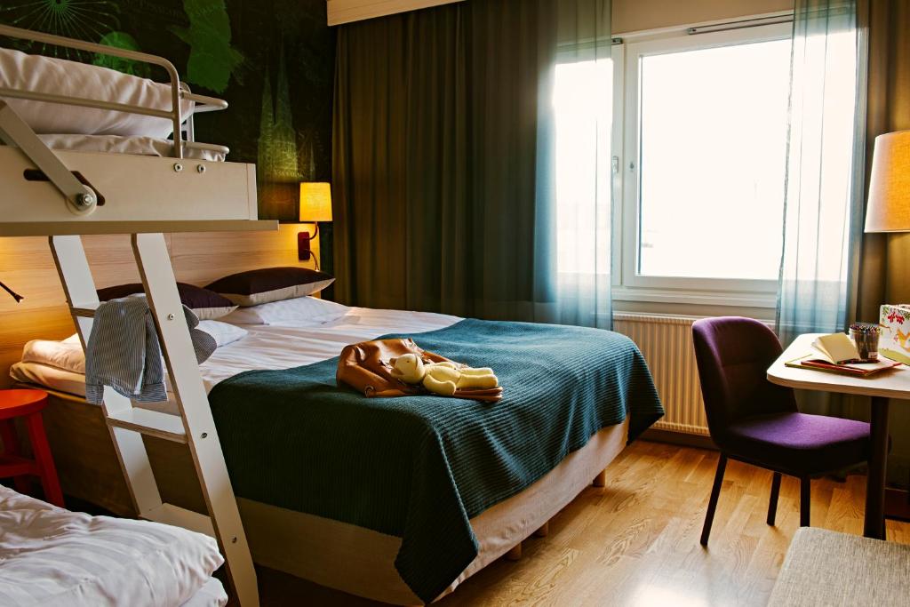 Scandic Uppsala Nord في أوبسالا: غرفة نوم بسريرين بطابقين وطاولة وكرسي