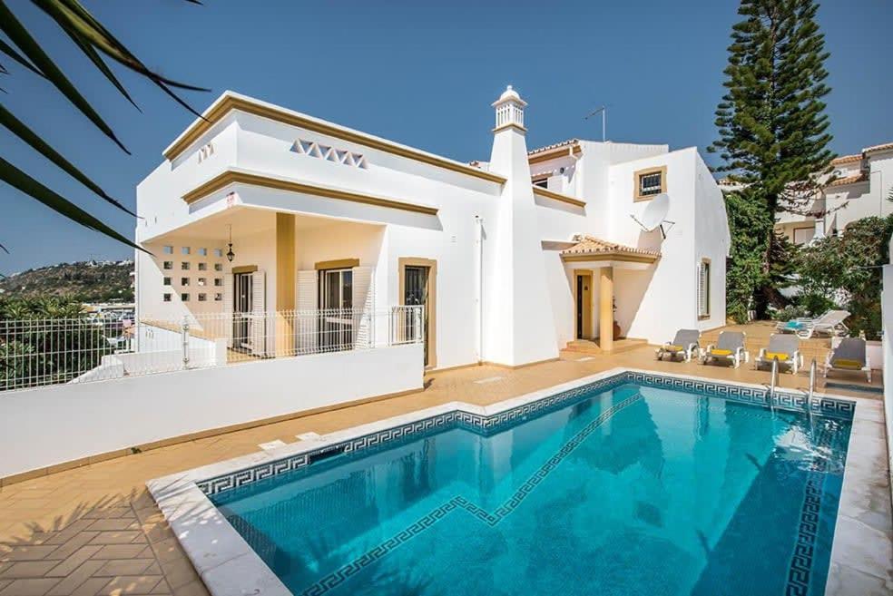 a villa with a swimming pool in front of a house at Villa Almanda - Spacious villa perfectly located between Albufeira Marina and the Old Town in Albufeira