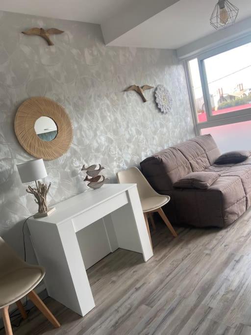 ein Wohnzimmer mit einem weißen Tisch und einem Sofa in der Unterkunft Mignon studio au cœur de Mèze in Mèze