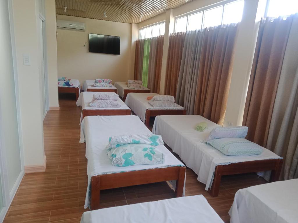 a row of beds in a room with a tv at bucana traveler's inn in Guinisiliban