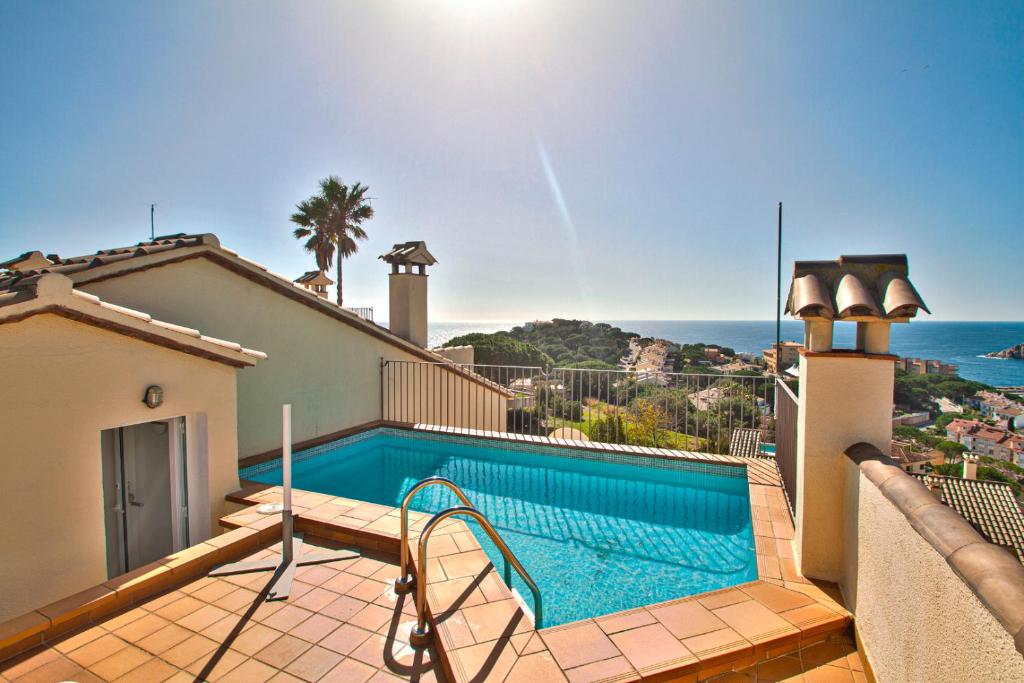une villa avec une piscine et l'océan dans l'établissement Club Villamar - Sereni, à Sant Feliu de Guíxols